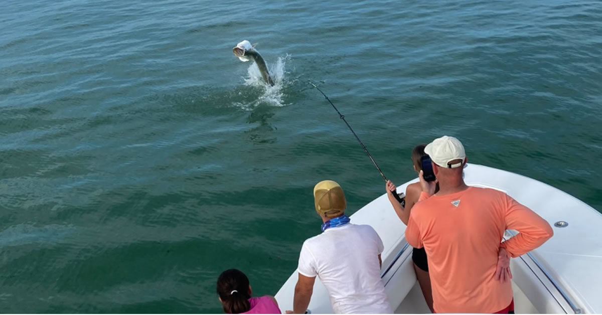 Anglers reeling in a jumping Tarpon